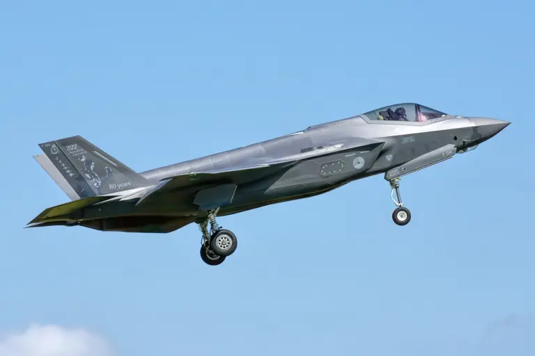 F-35-hävittäjä lentää sinisellä taivaalla, taustalla pilviä.