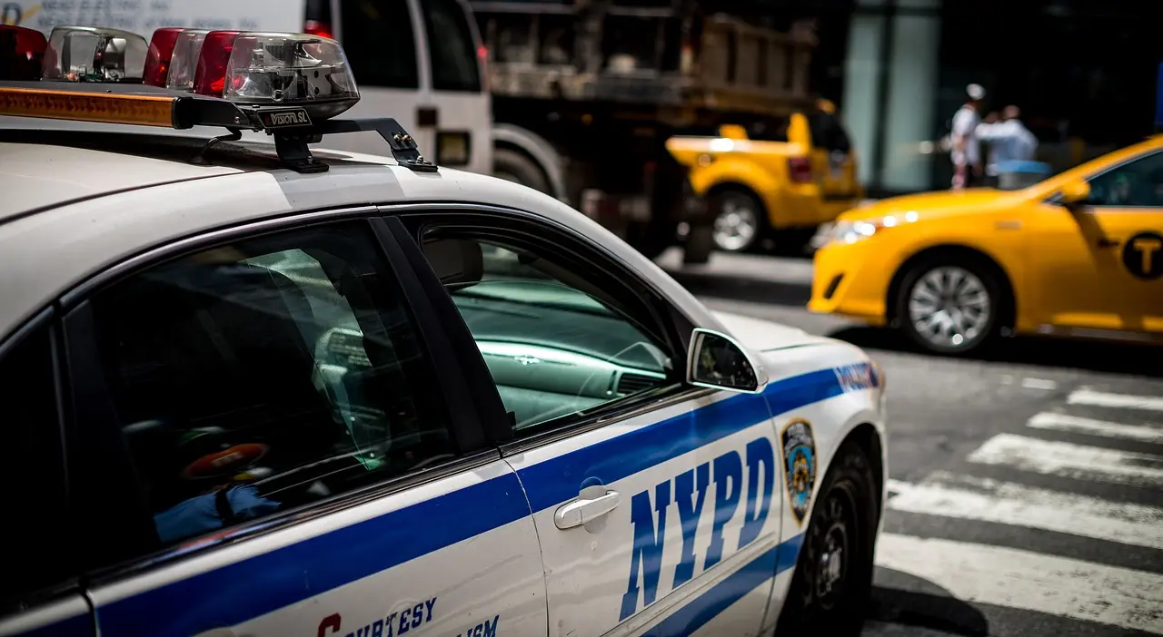 Poliisiauto pysähtynyt rikospaikan lähelle, valot vilkkuvat.
